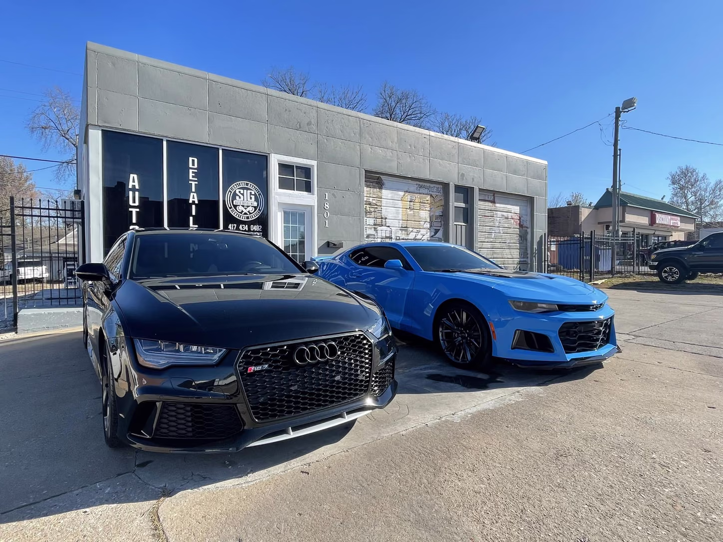 Audi and Camaro outside the shop